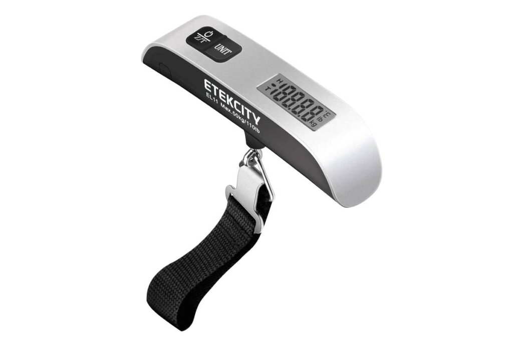 Digital luggage scale with a silver body, displaying weight in kg/lb, featuring a strap and buttons for power and unit change.