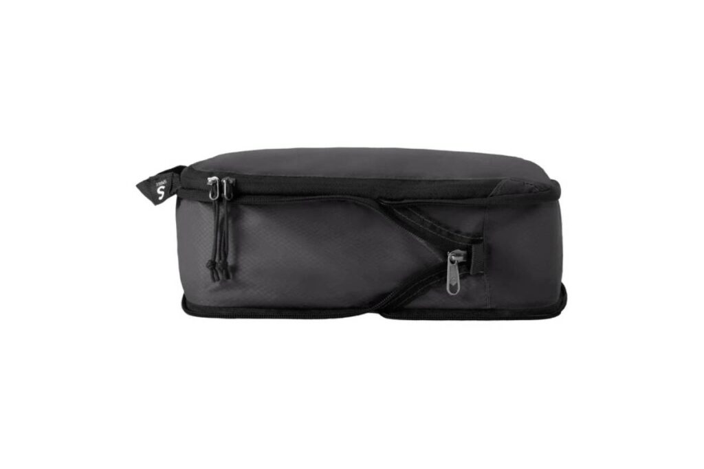 A sleek black packing cube with zippers and a top handle, designed for organized travel and efficient storage.