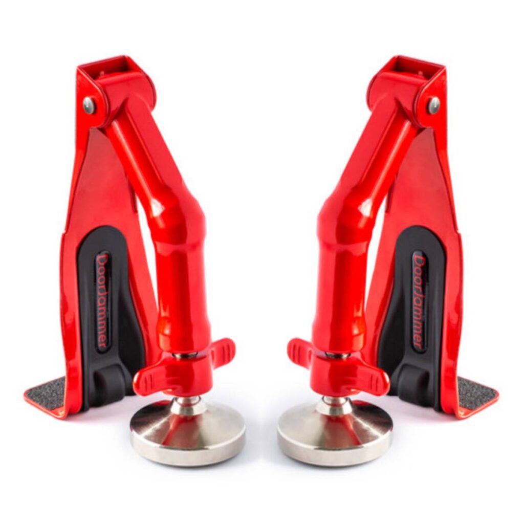 Two red door jammers with adjustable bases to hold doors securely in place on various surfaces.