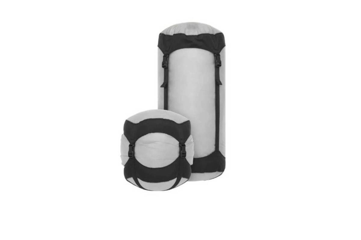  Two lightweight travel compression sacks in a gray fabric with black straps, one tall and slender, the other shorter and round.