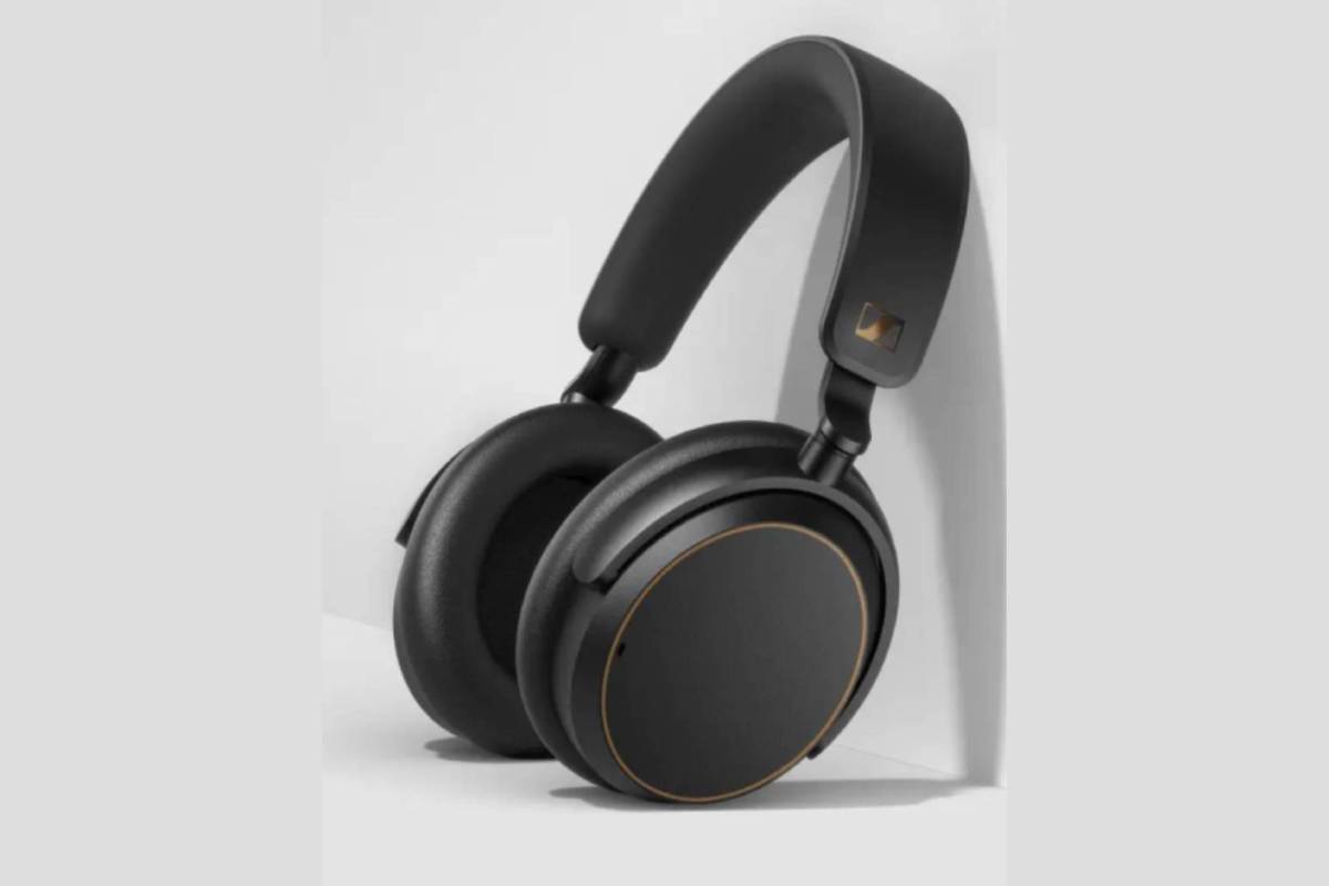  A sleek pair of black headphones with gold accents resting against a white wall, showcasing a modern design.